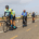 A group of people riding bikes down a road