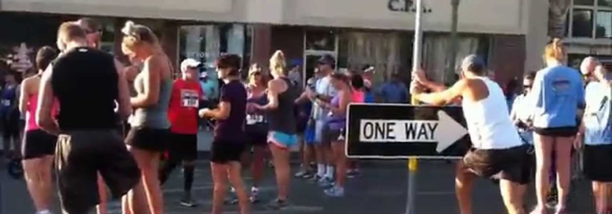 A group of people standing around a one way sign