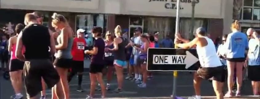 A group of people standing around a one way sign