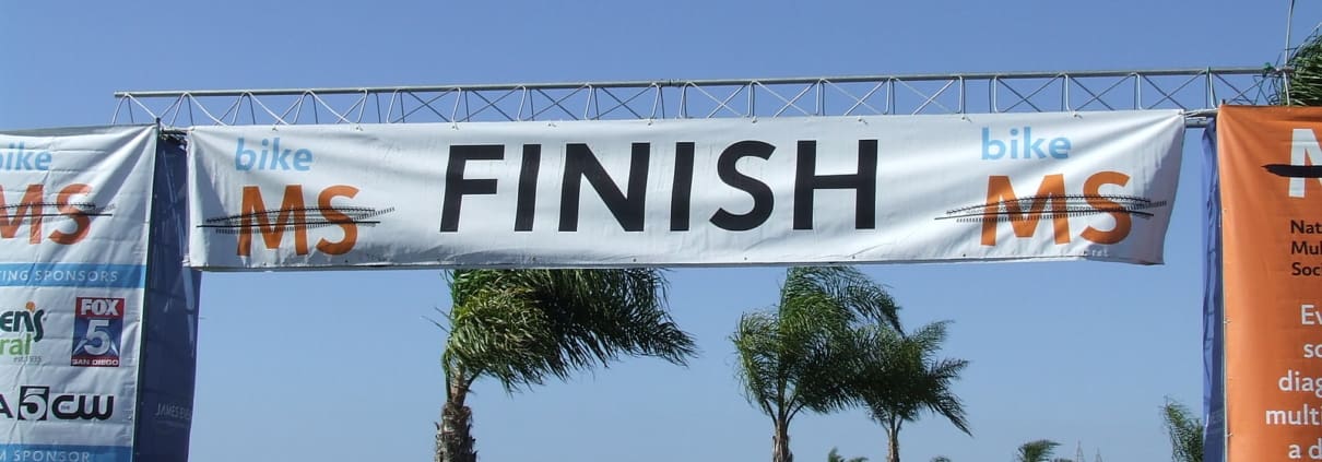 The finish line of a race with people walking under it