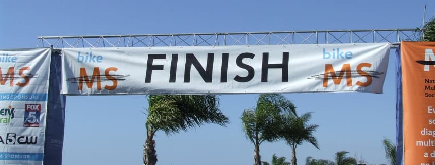 The finish line of a race with people walking under it