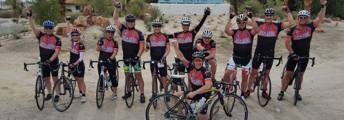 A group of men riding bikes on top of a dirt road