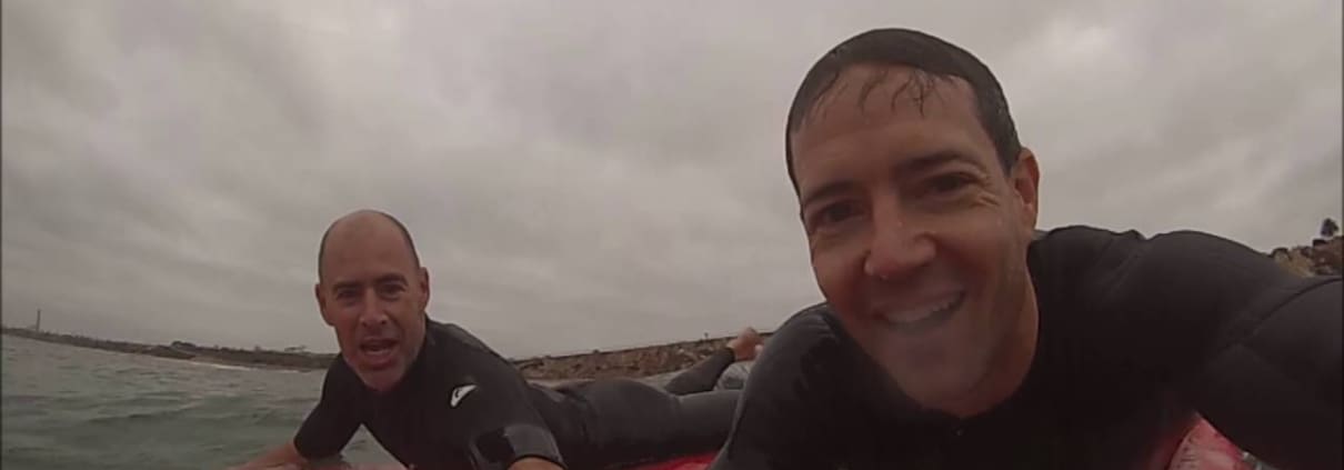 men riding on top of surfboards