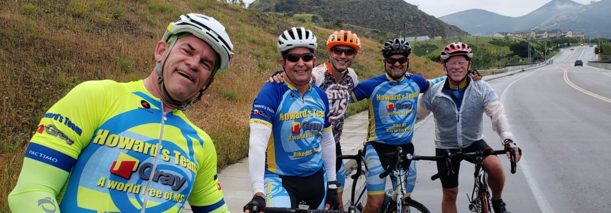 A group of men riding bikes down a road