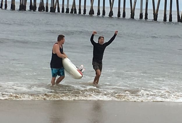 A couple of people that are standing in the water