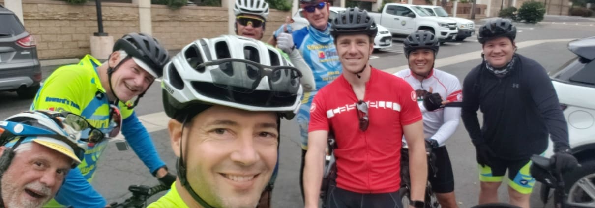 A group of men riding bikes down a street