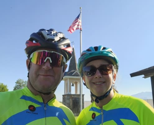 A man and a woman wearing helmets and sunglasses